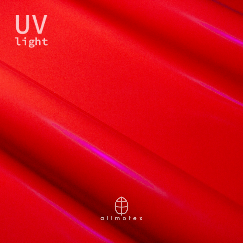 Close-up of tangerine orange glossy latex reacting to UV light with Allmotex logo.