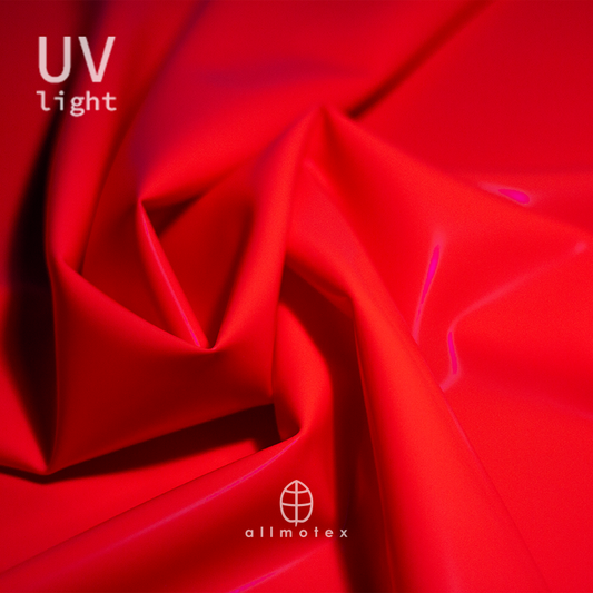 Close-up of tangerine orange glossy latex reacting to UV light with Allmotex logo.