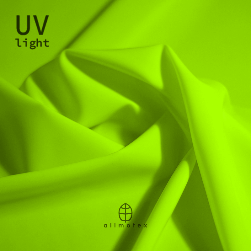 Close-up of yellow glossy latex reacting to UV light with Allmotex logo.